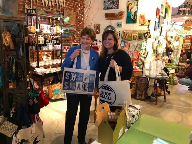 U.S. Sen. Jeanne Shaheen holds a "shop small" bag in Newmarket's Good Juju Tuesday. [Courtesy photo]