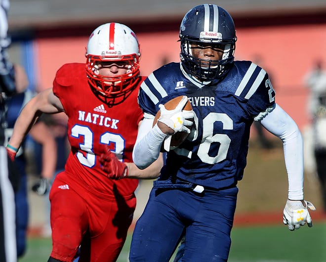 Playing in their last high school football games, Framingham senior captain Cam Haugabrook (right) runs away from Natick senior captain Tim Ramstrom for a touchdown in Natick's 35-6 win on Thanksgiving Day at Natick High School. [Daily News Staff Photo/Ken McGagh]