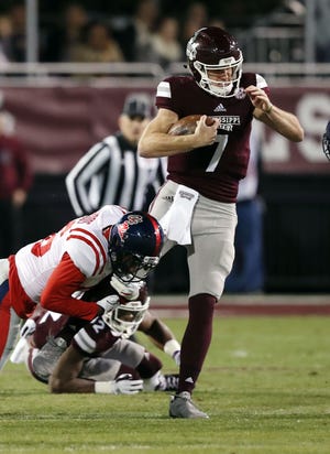 Mississippi State quarterback Nick Fitzgerald (7) is tackled by Mississippi's Zedrick Woods during the first half of an NCAA college football game in Starkville, Miss., Thursday. [ROGELIO V. SOLIS/AP PHOTO]
