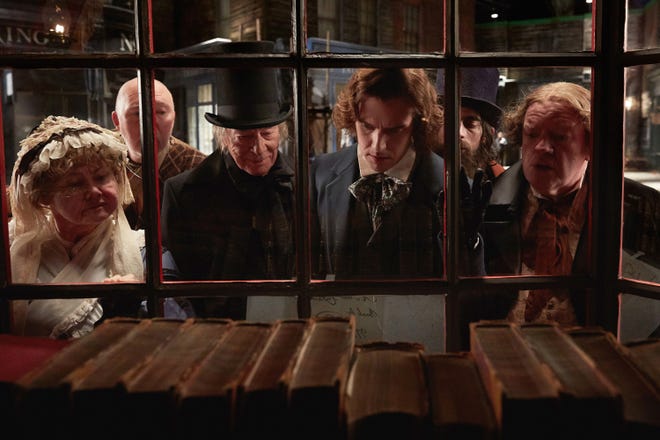 Christopher Plummer (center, left) stars as Ebenezer Scrooge and Dan Stevens (center, right) stars as Charles Dickens in director Bharat Nalluri's "The Man Who Invented Christmas." [Kerry Brown/Bleecker Street]