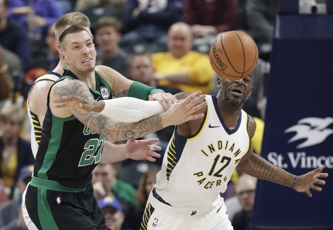 Boston's Daniel Theis, left, and Indiana's Damien Wilkins battle for a loose ball during NBA action Saturday. [AP photo]
