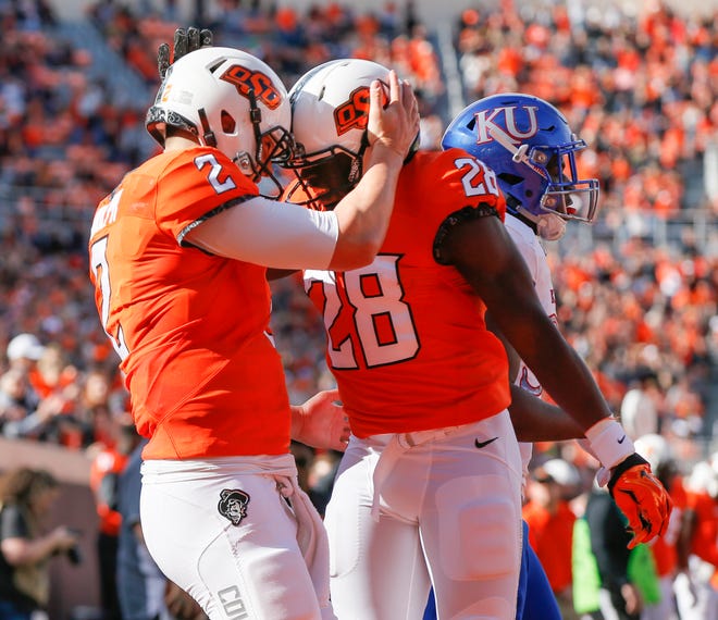 Oklahoma State's Mason Rudolph (2) and James Washington (28) celebrate a touchdown run by Rudolph in the first quarter during a college football game between the Oklahoma State Cowboys (OSU) and the Kansas Jayhawks (KU) at Boone Pickens Stadium in Stillwater, Okla., Saturday, Nov. 25, 2017. Photo by Nate Billings, The Oklahoman