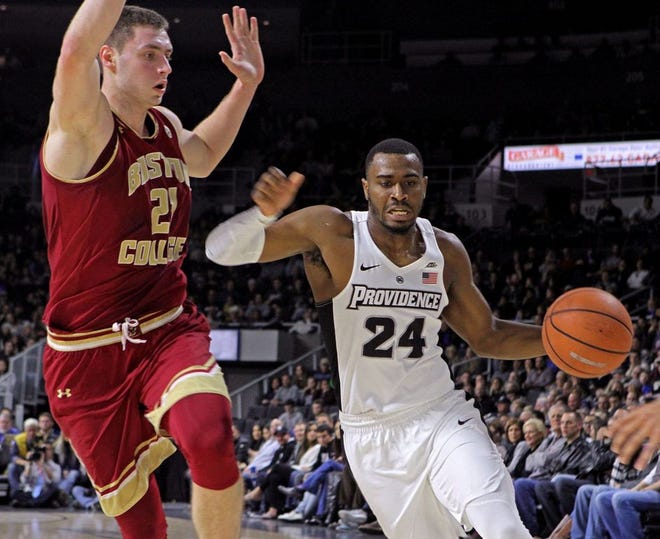 Providence's Kyron Cartwright drives to the basket against Boston College's Nik Popovic during Saturday night's game.