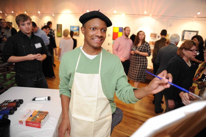 Devante Sims shows off his painting skills during An Evening of Arts that showcased students' art Thursday, Nov. 19, 2015, at the Harrison Galleries. The event benefits Arts 'n Autism, an after-school and summer camp program serving children, adolescents and young adults with autism. [File photo]