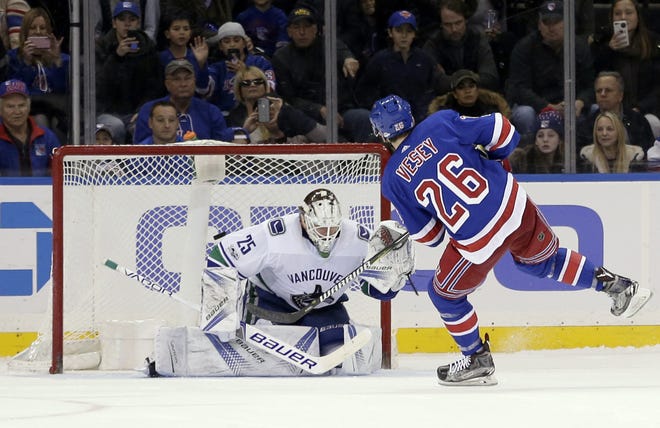 New York Rangers' Jimmy Vesey, right, scores the winning goal past Vancouver Canucks goalie Jacob Markstrom as the Rangers claim a 4-3 victory at home. [AP Photo/Seth Wenig]
