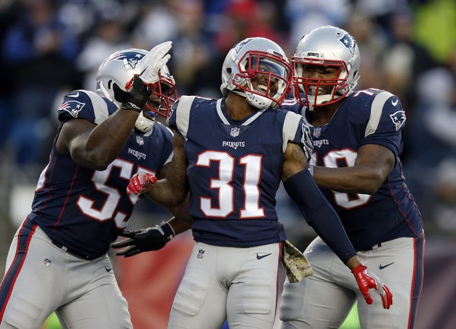 Patriots cornerback Jonathan Jones, center, celebrates with teammates after sacking Dolphins quarterback Matt Moore during the second half of Sunday's game, Sunday in Foxboro. [Michael Dwyer/The Associated Press]