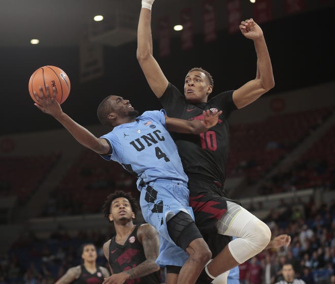 North Carolina's Brandon Robinson (4) drives on Arkansas's Daniel Gafford (10) in the second half during the Phil Knight Invitational tournament in Portland, Ore., on Friday. [AP Photo/Timothy J. Gonzalez]