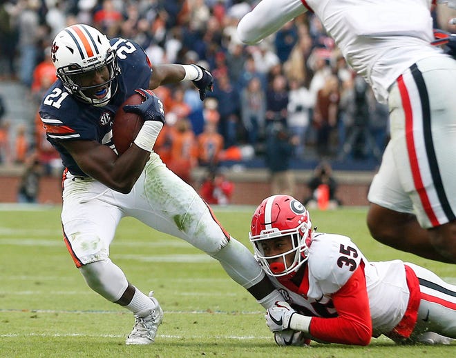 Auburn running back Kerryon Johnson is tackled by Georgia defensive back Aaron Davis during the first half of an NCAA college football game Saturday, Nov. 11, 2017, in Auburn, Ala. (AP Photo/Brynn Anderson)