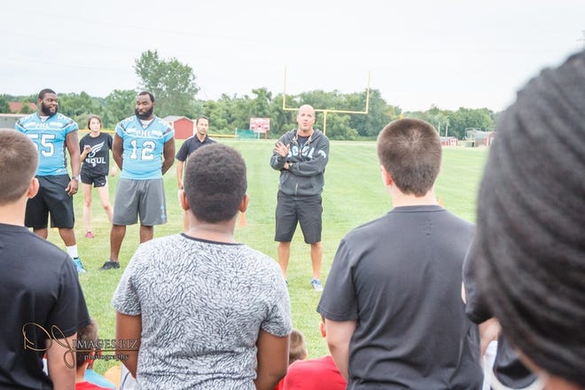 Philadelphia Soul players Daverin Geralds (left) and Brian Robinson help out at a youth football clinic in Mount Laurel as Tony Mahon addresses the players last summer. [COURTESY OF DAVID JACKSON]