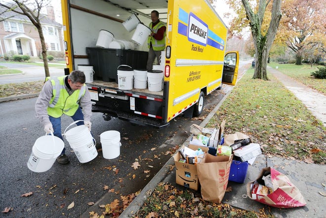 George Hunyadi, left, and Ray Leard of Innovative Organics Recycling collect compost from a home in Bexley that is part of a pilot program in the city. [Courtney Hergesheimer/Dispatch]