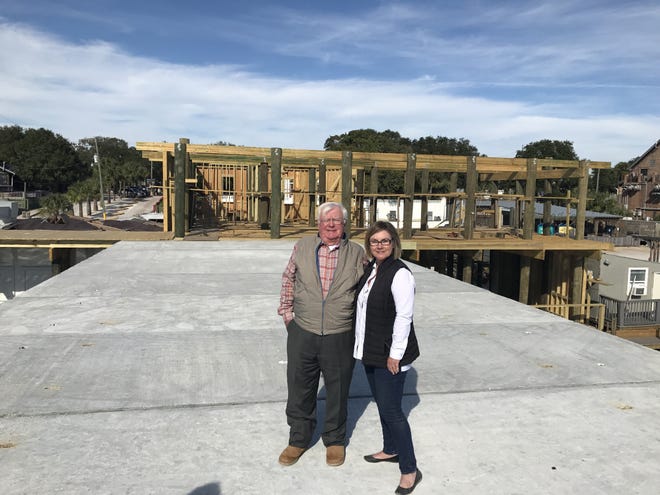 Claude Perry and his daughter, Kimberly, stand in front of the two-story restaurant building Claude is constructing on the Destin harbor. [ANNIE BLANKS/THE LOG]