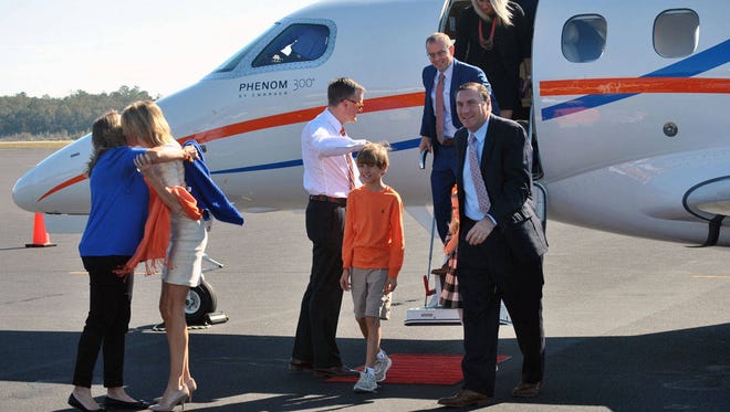 University of Florida’s new head football coach Dan Mullen, right, arrives at the airport in Gainesville on Monday. His wife, Megan, and son, Canon, are being greeted by Florida athletic director Scott Stricklin. (Mark Long/Associated Press)
