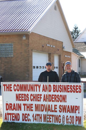 Steve Hoover, (R) poses with Police Chief Brian Anderson, and a sign he put next to Midvale Town Hall. (TimesReporter.com / Pat Burk)