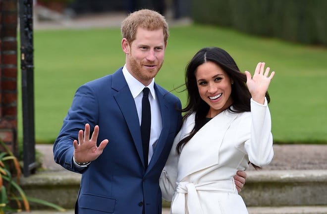 Britain's Prince Harry and Meghan Markle pose for the media in the grounds of Kensington Palace in London, Monday Nov. 27, 2017. It was announced Monday that Prince Harry, fifth in line for the British throne, will marry American actress Meghan Markle in the spring, confirming months of rumors. (Eddie Mulholland/Pool via AP)