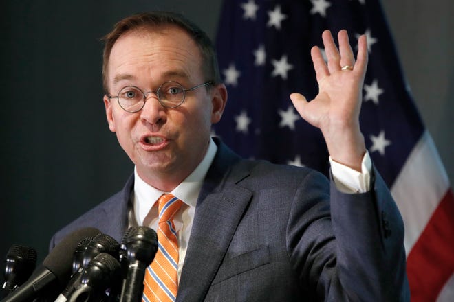 Mick Mulvaney holds up his hand as he speaks during a news conference after his first day as acting director of the Consumer Financial Protection Bureau in Washington, Monday, Nov. 27, 2017. (AP Photo/Jacquelyn Martin)