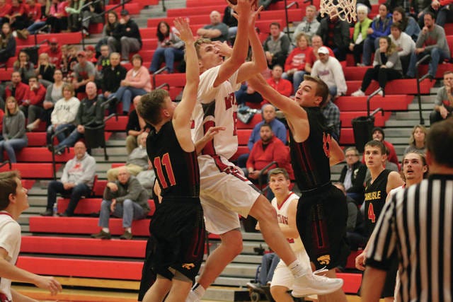 Steve Borneman goes up for a shot through two Wildcats on Nov. 27. Borneman led the Mustangs with a total of 22 points. PHOTO BY BAILEY FREESTONE/DALLAS COUNTY NEWS