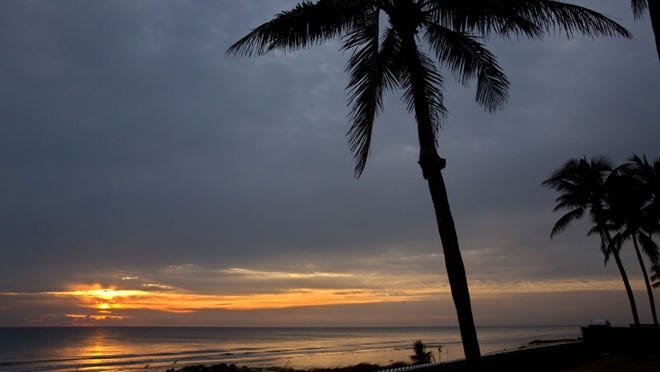 The sun rises into a cloudy sky off Midtown Beach in Palm Beach. (Lannis Waters/The Palm Beach Post)