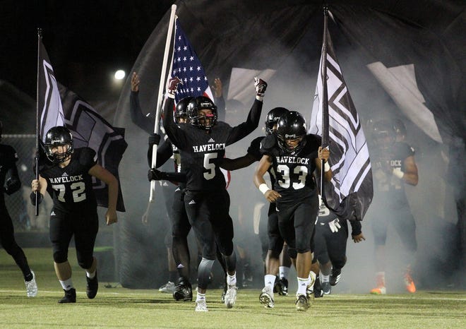 The Havelock Rams waive flags as they exit the tunnel onto the game field prior to a game earlier this season. Havelock is playing in its eighth eastern final in the past nine years Friday night at Western Alamance. [GRAY WHITLEY / SUN JOURNAL STAFF]
