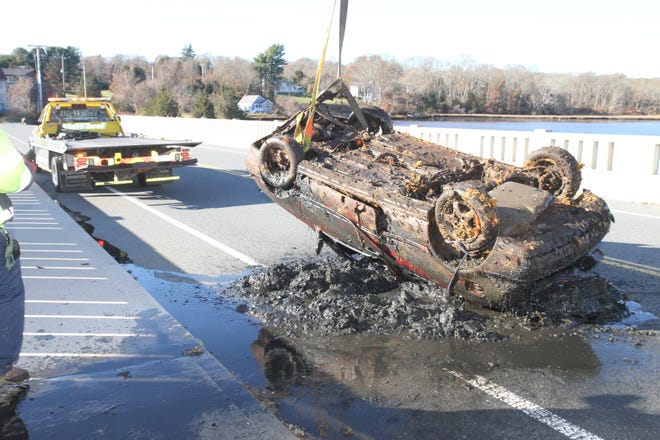 Silt oozes from a red Volkswagen after it was recently pulled from the Westport River. [Photo Courtesy EverythingWestport.com]