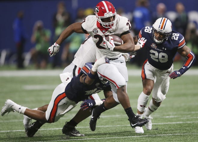 Georgia running back Nick Chubb (27) breaks the tackle of Auburn linebacker Darrell Williams (49) during the second half of the Southeastern Conference championship NCAA college football game, Saturday in Atlanta. [JOHN BAZEMORE / ASSOCIATED PRESS]