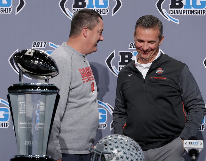 Wisconsin head coach Paul Chryst, left, talks with Ohio State head coach Urban Meyer during a news conference for the Big Ten Conference championship NCAA college football game, Friday, Dec. 1, 2017, in Indianapolis. Wisconsin will play Ohio State on Saturday for the championship. (AP Photo/Darron Cummings)
