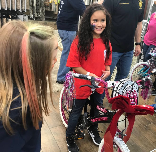 Avianna, 8, said she loved her bike she received as a gift from Yates Flooring Center, the last stop for the annual Santa Cops event on Saturday afternoon. (Erica Pauda/A-J Media)