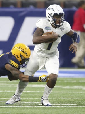 University of Akron quarterback Kato Nelson is caught from behind by Toledo's Adeniyi Olasunkanmi during the first quarter of the MAC Championship game on Saturday at Ford Field in Detroit. The Zips lost the game 45-28. (Phil Masturzo/ Beacon Journal/Ohio.com)