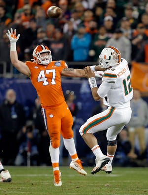 Clemson's James Skalski (47) stops a pass by Miami's Malik Rosier (12) during the first half of the Atlantic Coast Conference championship game Saturday night in Charlotte, N.C. [BOB LEVERONE/The Associated Press]