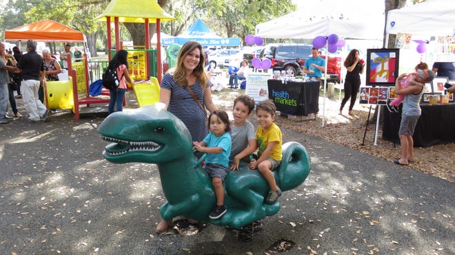 Idalisa Sierra, 33, of Lakeland, attended the Festival del Aguinaldo (Festival of Carols) Sunday at Hunt Fountain Park in Lakeland with her sons (from left to right) Matias (1), Sebastian (6) and Nicolas (4). [KEVIN BOUFFARD/THE LEDGER]