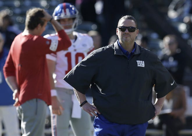 FILE - In this Dec. 3, 2017, file photo, New York Giants head coach Ben McAdoo is shown in front of quarterback Eli Manning (10) before an NFL football game against the Oakland Raiders, in Oakland, Calif. A person familiar with the situation says Ben McAdoo has been fired as coach of the New York Giants and Jerry Reese is out as general manager less than a year after taking the team to the playoffs for the first time since 2011. McAdoo and Reese were fired Monday, Dec. 4, 2017, a day after the Giants were beaten in Oakland and dropped to 2-10, according to the person who spoke on condition of anonymity because the team had not made an official announcement.  (AP Photo/Ben Margot, File)