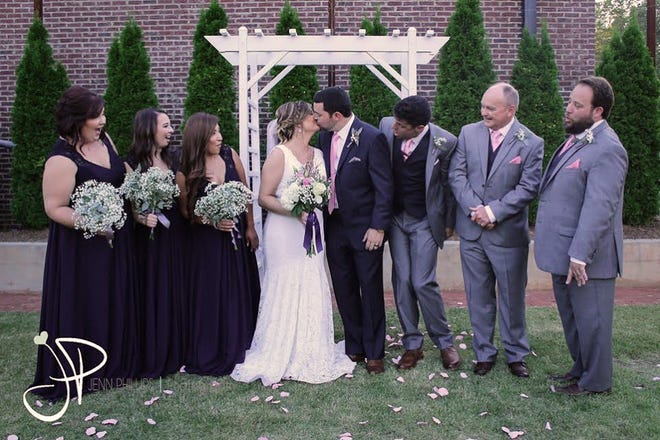 Lara Elizabeth Donnelly and Jackson Kent Barkley after exchanging wedding vows as members of the wedding party look on. [SUBMITTED PHOTOS]