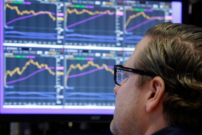 Specialist Gregg Maloney works at his post on the floor of the New York Stock Exchange on Monday. Stocks rose Monday on expectations that lower taxes will help corporate profits pile up even higher. [AP Photo / Richard Drew]