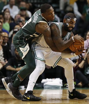 Milwaukee's Eric Bledsoe, left, tries to strip the ball away from Boston's Kyrie Irving during Monday's 111-100 win by the Celtics. [AP photo]
