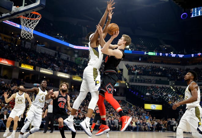 Chicago Bulls forward Lauri Markkanen (24) shoots over Indiana Pacers center Myles Turner during the first half of an NBA basketball game in Indianapolis, Wednesday, Dec. 6, 2017. (AP Photo/Michael Conroy)