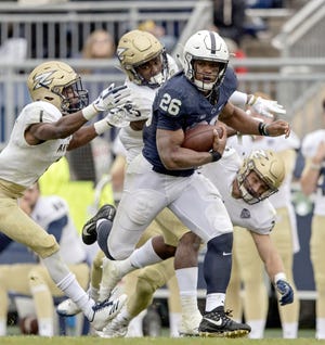 In this Sept. 2, 2017, photo, Penn State running back Saquon Barkley runs from a pack of Akron defenders during an NCAA college football game in State College, Pa. Barkley was selected to the AP All-Conference Big Ten team announced Wednesday. [AP FILE PHOTO]