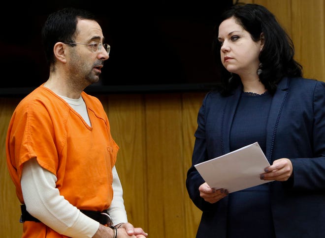 Former sports doctor Larry Nassar, left, stands with his attorney Shannon Smith as he pleads guilty to three counts of first-degree criminal sexual conduct Wednesday, Nov. 29, 2017, in Judge Janice Cunningham’s courtroom in Eaton County, Mich. (Matthew Dae /Lansing State Journal via AP)