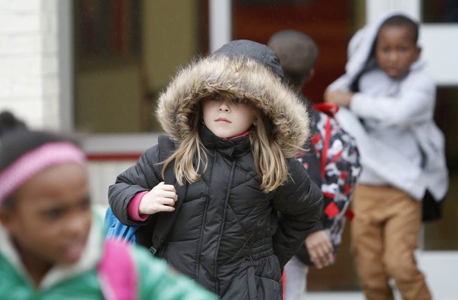 North Bay Elementary School student Vivian Moore, 7, of Biloxi, Miss., braces against the cold weather as she walks to her bus after school on Wednesday, Dec., 6, 2017. Forecasters say conditions could be right for snowfall in South Mississippi late Thursday or early Friday. [John Fitzhugh/The Sun Herald via AP]