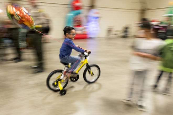 Frank James gives his new bike a test ride during the 14th annual Doris Davies Memorial Bicycle Giveaway at the San Bernardino County Fairgrounds on Wednesday. [James Quigg, Daily Press]