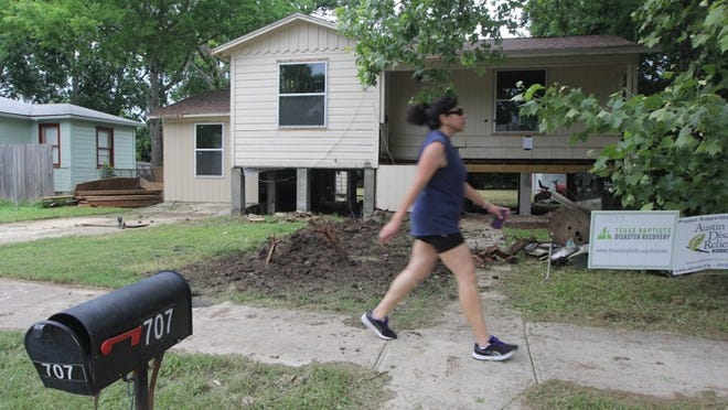 Celia Rosales walks in front of a house that was damaged during the 2015 Memorial Day floods in San Marcos. MARLON SORTO / AHORA SI.