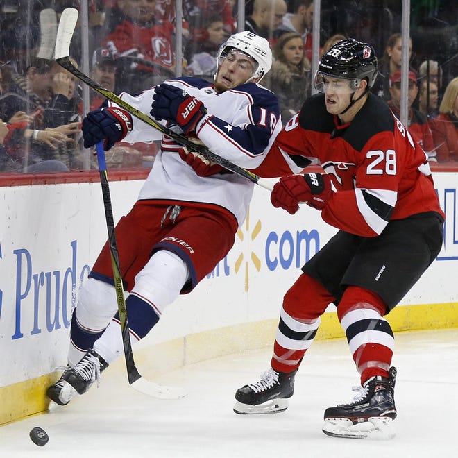 New Jersey defenseman Damon Severson competes for the puck with Blue Jackets center Pierre-Luc Dubois during the first period Friday in Newark, N.J. [Adam Hunger/The Associated Press]