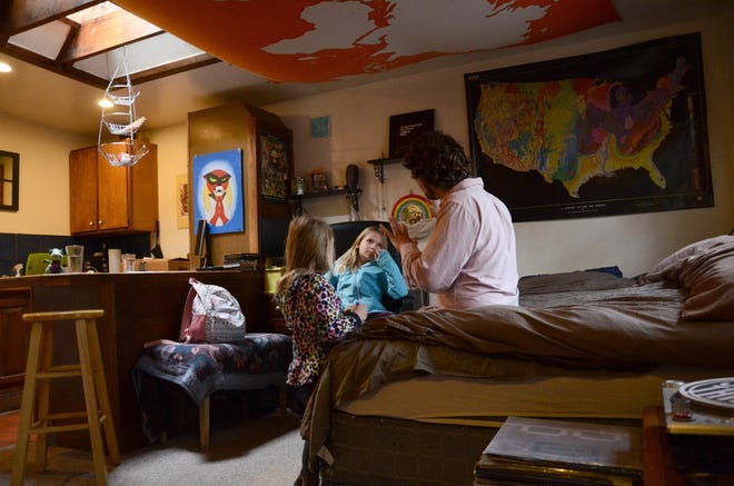 A man sits with his two daughters, who are recipients of the Children's Health Insurance Program. The program provides low-cost coverage to families who earn too much to qualify for Medicaid. [AP Photo/Tatiana Flowers]