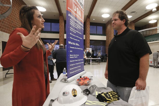 In this Thursday, Nov. 2 photo, a recruiter from a driller in the shale gas industry, left, speaks with an attendee at a job fair in Cheswick, Pa. [AP Photo/Keith Srakocic]