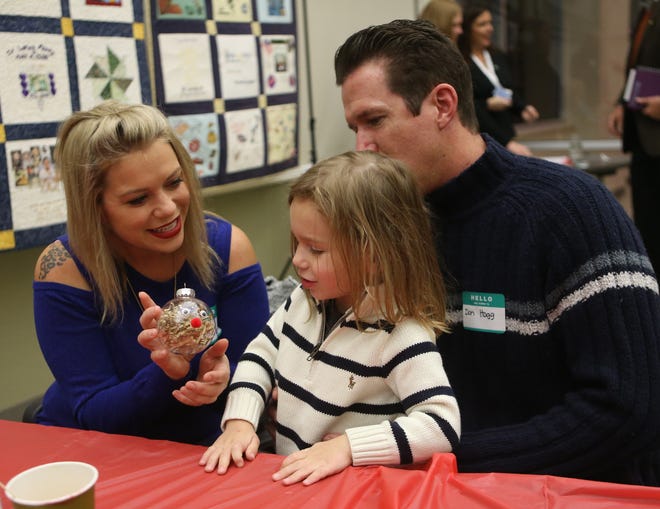 Jessica Ayers and Don Hogg help 3-year-old Jax make a reindeer ornament. Families gathered for the annual Tree of Life ceremony at Bay Medical on Thursday. Attendees made Christmas ornaments for family members who have passed away and shared their stories. The ornaments will be on display at the hospital throughout December. Go to newsherald.com for a related video. [PATTI BLAKE/THE NEWS HERALD]