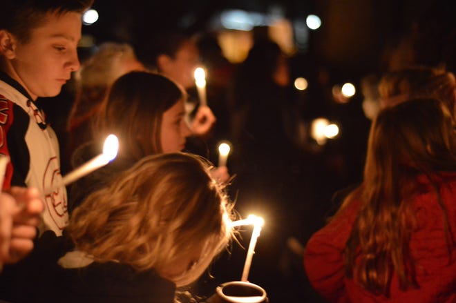 Aztec High School students and area residents gather for a candlelight vigil in Aztec, N.M., Thursday, Dec. 7, 2017, after a shooting at the high school. Students hid in their classrooms, some behind locked doors, as a suspect opened fire Thursday inside the school, killing two classmates before he died. (AP Photo/Russell Contreras)