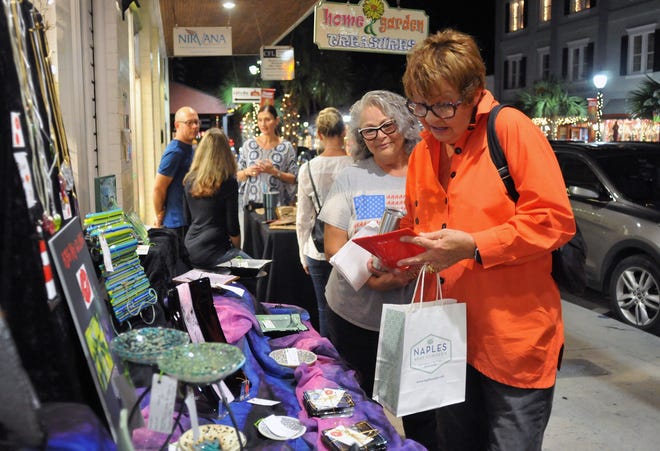 Judi Jones admires glass art by Marla Montgomery on Friday during Mount Dora Arts Splash. The Mount Dora Center for the Arts sponsors the event , featuring artists and musicians, every second Friday of each month. [Tom Benitez / Correspondent]