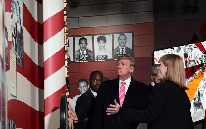President Donald Trump, center, listens to Museum Division Director Lucy Allen, right, during a tour of the newly opened Mississippi Civil Rights Museum in Jackson, Miss., Saturday, Dec. 9, 2017. Housing and Urban Development Secretary Ben Carson, left, joins the president on the tour. (AP Photo/Susan Walsh)