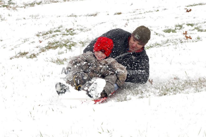 Allen and Cooper Alexander, 4, spin around while sledding down a hill Friday Dec. 8, 2017, in Vicksburg, Miss. Heavy snow fell across several Southern states Friday. (Courtland Wells/The Vicksburg Post via AP)