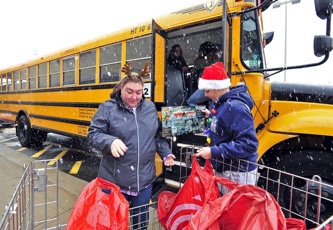 Maria Melo and her nephew Brendin Melo hand off donated Christmas presents during the "Fill the Bus" campaign outside of the Target store in Dartmouth.

[DAVID W. OLIVEIRA/STANDARD-TIMES SPECIAL/SCMG]