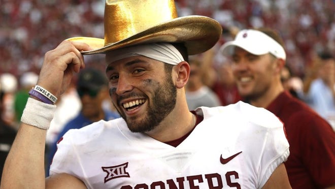 Oklahoma quarterback Baker Mayfield celebrates with the Golden Hat Trophy after the team’s 29-24 win over Texas in October. Mayfield is the first quarterback to finish in the top four of the Heisman Trophy balloting three times. (AP Photo/Ron Jenkins, File)