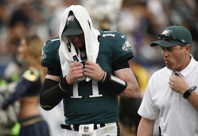 Eagles quarterback Carson Wentz leaves the field after sustaining a knee injury during the second half against the Los Angeles Rams Sunday. [KEVIN KUO / THE ASSOCIATED PRESS]